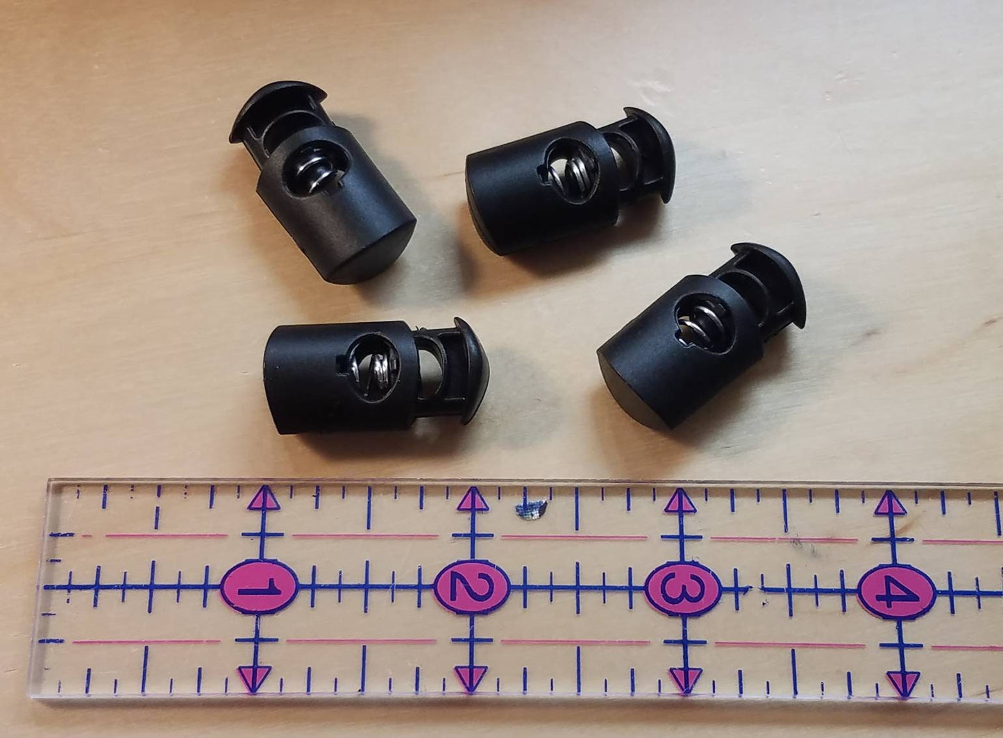 Cord adjuster 'cinch' clamps, oblong style, pk/4, black. Secure mask straps for better fit. Replacement clamps for drawstring cords.